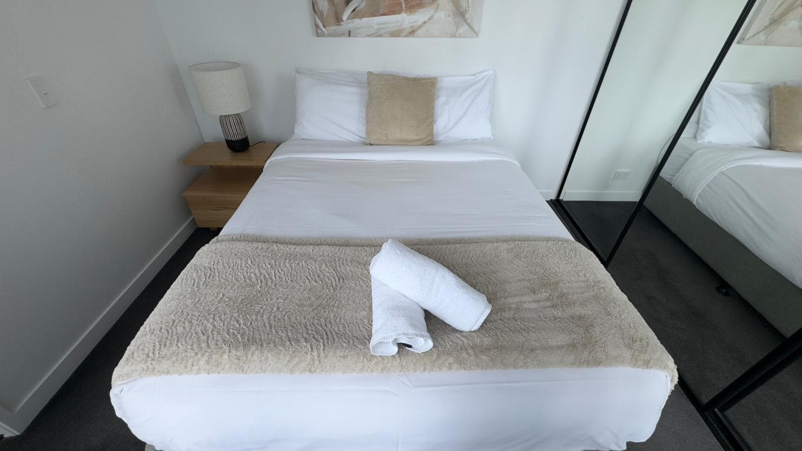 Guest-ready bed with rolled hotel towels by Ventumm in Brisbane